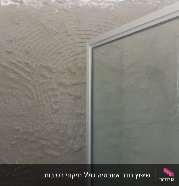 קיר עם טיח טרי ודלת זכוכית במקלחת